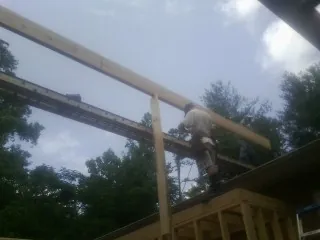 Carpenter setting a ridge beam over a new addition frame — Ice Dam Removal by Roofing Brothers in Hazel Green