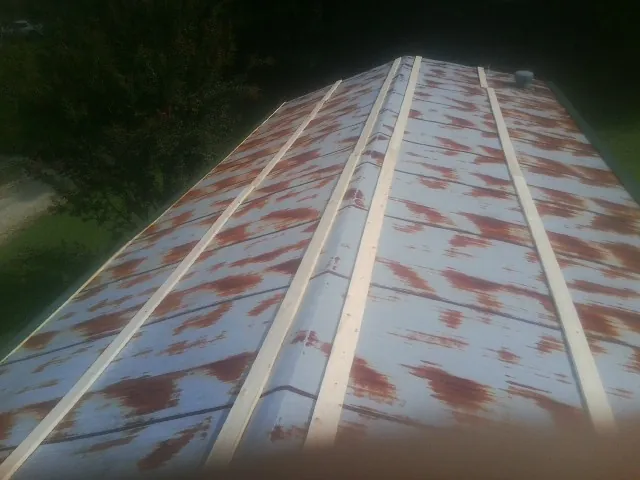 Rusted metal roof panels with new wood purlins before replacement — Storm Damage Roof Repair in Hazel Green by Roofing Brothers