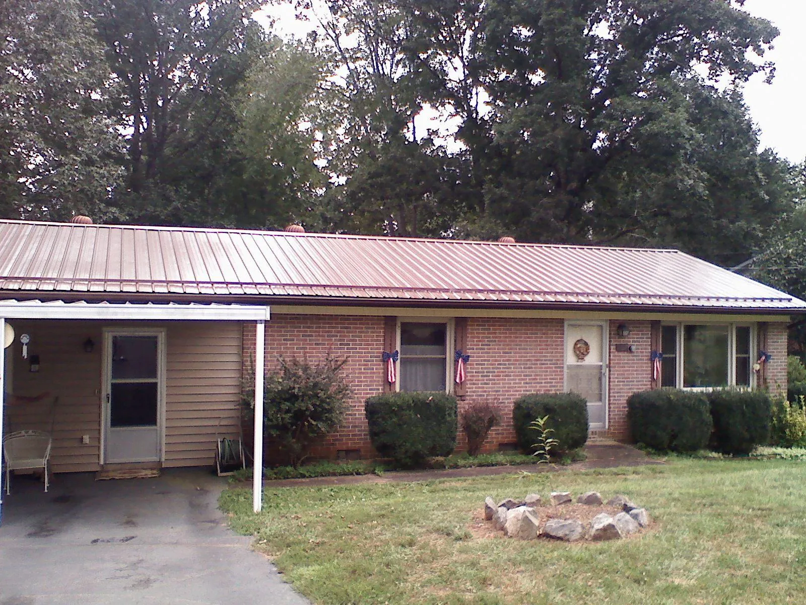 Bronze metal roof and carport on a brick ranch home — Roof Repair work by our crew in Hazel Green